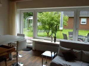 a living room with a couch and a large window at meine-nordsee-fewo in Esens
