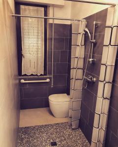 a bathroom with a toilet and a shower with a window at Diamond Apartment in Cattolica