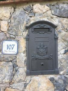 a black post box on the side of a stone wall at Cinque Terre Experience by Amedeo in Piano di Follo