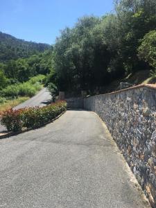 a road with a stone wall next to a street at Cinque Terre Experience by Amedeo in Piano di Follo