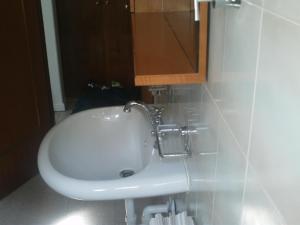 un lavandino bianco in un bagno con specchio di HOTEL RISTORANTE VITTORIA dal 1920 a Marzio