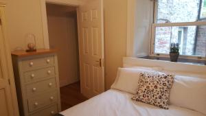 Schlafzimmer mit einem Bett mit einem Kissen und einem Fenster in der Unterkunft Historic Hideaway in Cork City Centre in Cork