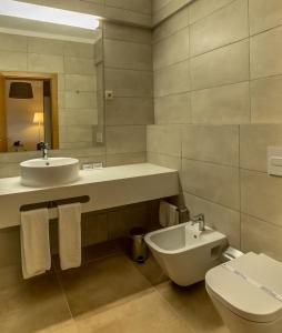 a bathroom with a sink and a toilet and a mirror at Flor Da Rocha in Portimão
