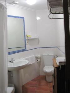 a bathroom with a sink and a toilet and a mirror at Hotel Olimpia in Albarracín