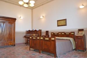 a bedroom with a bed and a desk and a piano at Palazzo Vallebona in Gallipoli