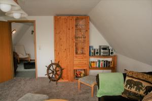 a living room with a wooden cabinet and a chair at Zur Schatztruhe in Nordstrand
