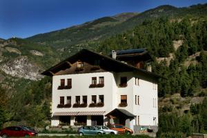 a large white building with cars parked in front of it at Hotel Edelweiss in Villeneuve