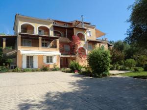 a large house with a driveway in front of it at Pasiphae Holiday Apartments in Kontokali