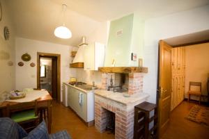 a kitchen with a brick fireplace in the middle of a room at B&B Il Pettirosso di Siena in Siena