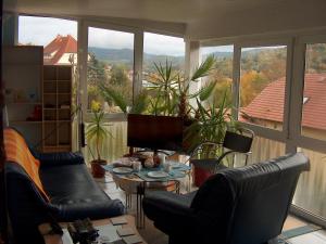 ein Wohnzimmer mit schwarzen Ledermöbeln und einem großen Fenster in der Unterkunft Ferienwohnung Trollmann in Schmalkalden