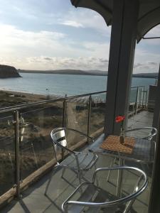 a balcony with a table and chairs and the ocean at Hotel Kamenec in Kiten