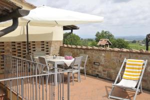 une terrasse avec une table et un parasol dans l'établissement Agriturismo Renai e Monte II, à Gambassi Terme