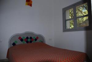 a bedroom with a bed and a window at Residence Ribellinu in Pianottoli-Caldarello