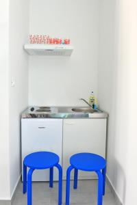 una cocina con dos taburetes azules frente a un fregadero en Flamingo, en Split