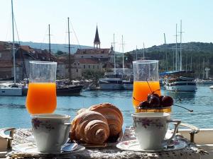 a table with two glasses of orange juice and bread at Holiday home Gariful in Milna