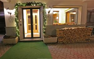 una porta d'ingresso di un negozio con un mucchio di legno di Hotel Biancospino a Lanzada