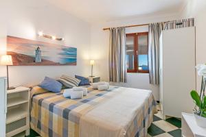 1 dormitorio con 1 cama y un faro en la pared en Apartment Sa Fornera, en Alcudia