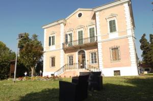 una grande casa su un prato di fronte di Tenuta Villa Colle Sereno a Montemarciano