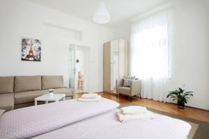 a white bedroom with a bed and a couch at Angel City Aparthotel in Prague