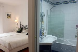 a bathroom with a shower, sink, and tub at Hotel Malaga Picasso in Málaga