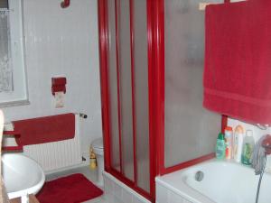 a bathroom with a red shower curtain and a sink at Ferienwohnung Trollmann in Schmalkalden