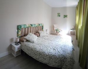 - une chambre avec un grand lit et une chaise dans l'établissement Apartmentos El Alfar del Sacramento, à Tolède