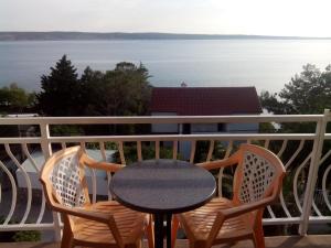 a table and chairs on a balcony with a view of the water at Apartments Ivanka in Starigrad