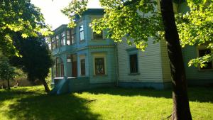 an old house with a tree in front of it at Villa Apartments by the sea in Liepāja