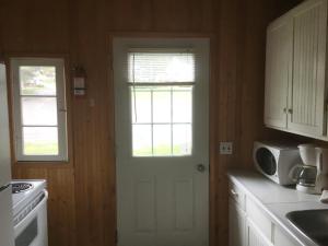 a kitchen with a stove top oven and a window at Merland Park Cottages and Motel in Picton