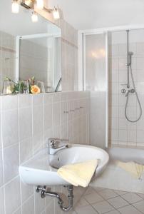 La salle de bains est pourvue d'un lavabo, d'un miroir et d'une baignoire. dans l'établissement Haus Buchenhof, à Heringsdorf