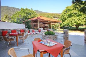 a patio with tables and chairs and a gazebo at Maria Studios in Neo Klima