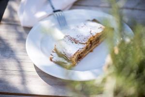 un pezzo di torta su un piatto bianco su un tavolo di Hotel Gnollhof a Chiusa