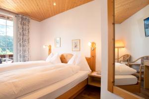 1 dormitorio con 2 camas y ventana en Hotel Sonnenberg, en Grindelwald