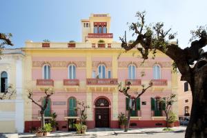 a pink building with a tower on top at Palazzo Vallebona in Gallipoli