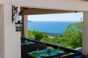 a dining room with a view of the ocean at Apartment & Rooms Savonari in Orasac