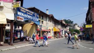 a group of people crossing a street in a city at Apartmani LolaNola in Vrnjačka Banja