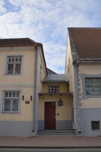 uma casa com uma porta vermelha e dois edifícios em Kuninga City Center Apartment em Pärnu