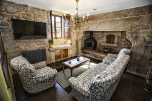 sala de estar con 2 sofás y chimenea en A Casa da Gandara en Camariñas