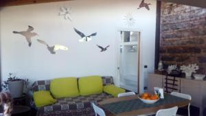 sala de estar con sofá y pájaros en la pared en Creative Apartment en Catania