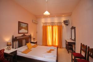 a bedroom with a bed and a desk and a window at Maria Studios in Neo Klima