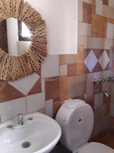 a bathroom with a toilet and a sink and a mirror at Hosteria La Pushka in Purmamarca