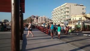 a group of people walking on a boardwalk at Casa de Praia em Arraial Cabo-RJ in Arraial do Cabo