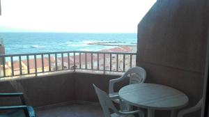 een balkon met een tafel en stoelen en de oceaan bij Apartamentos Copacabana Playa in La Manga del Mar Menor