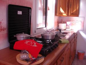 a kitchen with a stove with pots and pans on it at villa les Grenadines in Entre-Deux