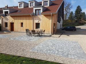 une terrasse avec des chaises et une table en face d'une maison dans l'établissement L'Ecrin du Lac, à Saint-Point-Lac