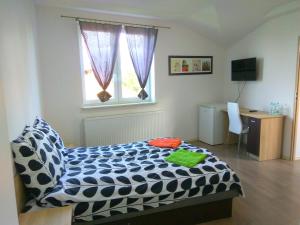 a bedroom with a bed and a desk and a window at Chill Out Wygryny in Ruciane-Nida