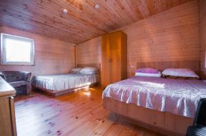 a bedroom with two beds in a wooden cabin at Poilsiavietė Elnias in Šventoji