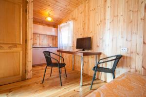 シュヴェントイにあるPoilsiavietė Elniasの椅子2脚、テーブル、テレビが備わる客室です。