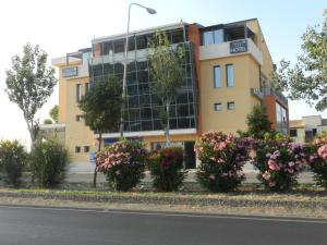 ジェーラにあるErasmus Hotelの花の目の前の黄色い建物