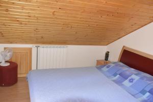 ein Schlafzimmer mit einem Bett und einer Holzdecke in der Unterkunft Apartments Bakuk in Stari Grad
